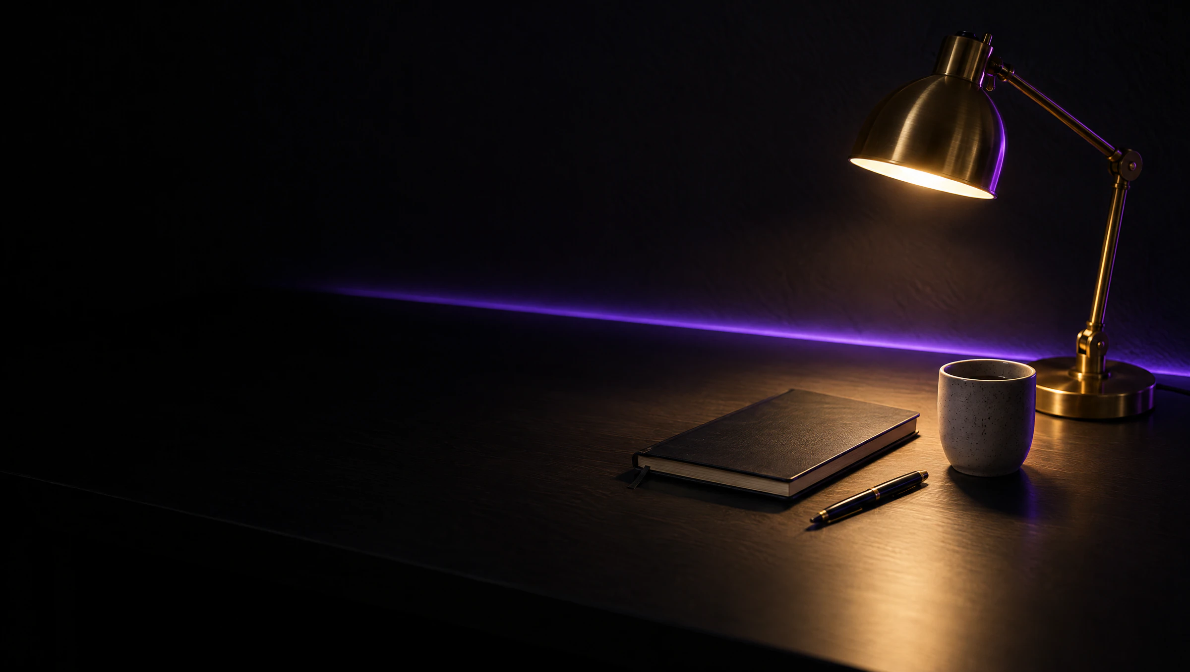 A dark desk lit by a brass lamp, with a closed notebook, a pen and a stone cup, and a thin purple light along the wall.